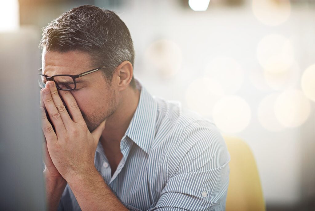 a uk manufacturing manager rubbing his eyes in frustration because he doesn't use a good MRP system